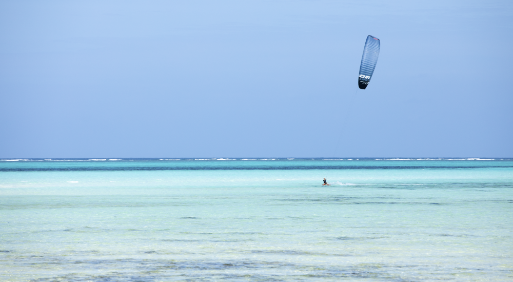 Photo of a kitesurfer surrounded by clear water