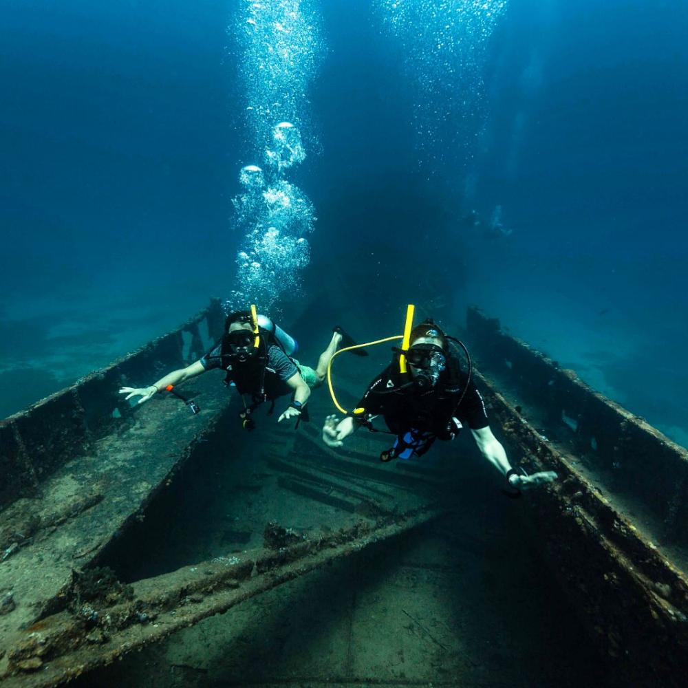 Two divers explore a wreck underwater in Anguilla