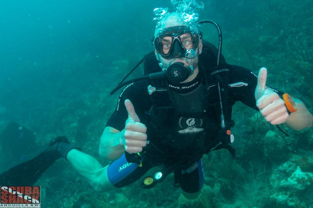 A man in scuba gear enjoys himself while scuba diving in Anguilla